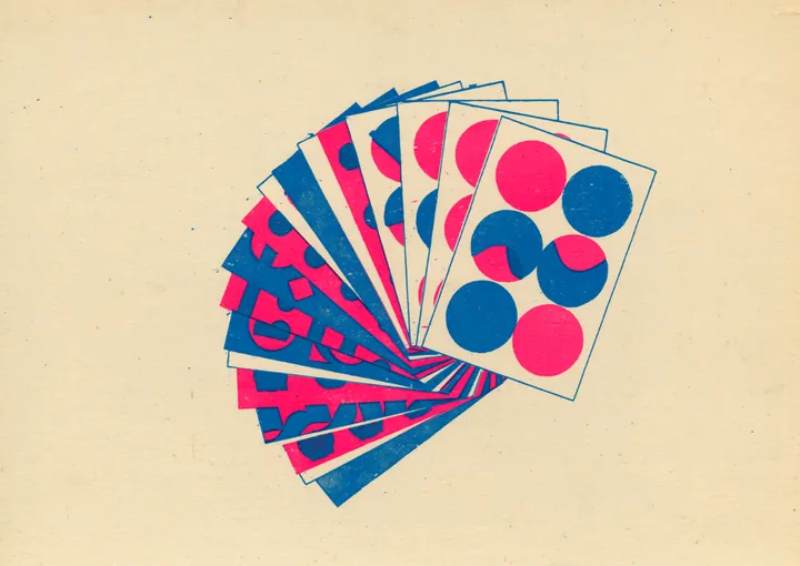A fanned deck of color swatch cards in pink, blue and cream with dot motifs