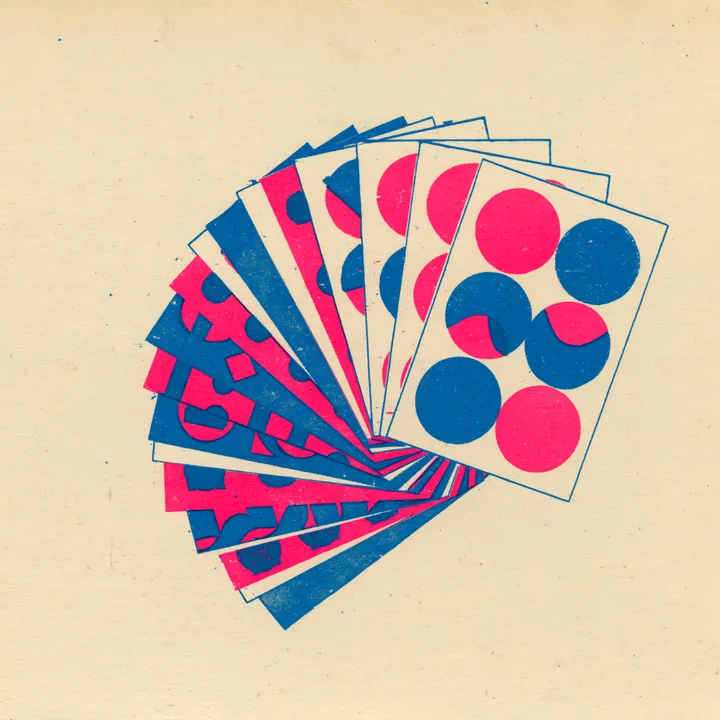 A fanned deck of color swatch cards in pink, blue and cream with dot motifs